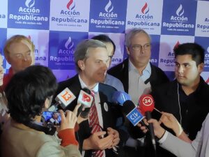 Chile president surrounded by reporters.